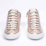 Front view of mid top rose-gold sneaker with full leather upper with perforated crown logo, internal zip and white sole.