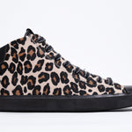Profilo laterale del mid top leopardato sneaker con tomaia in pelle di vitello a pelo pieno, zip interna e suola nera.