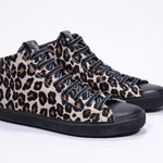 Three quarter front view of mid top leopard print sneaker with full hair calf leather upper, internal zip and black sole.