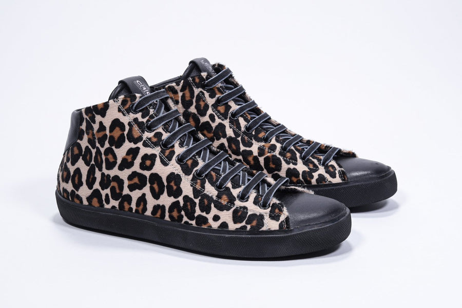 Three quarter front view of mid top leopard print sneaker with full hair calf leather upper, internal zip and black sole.