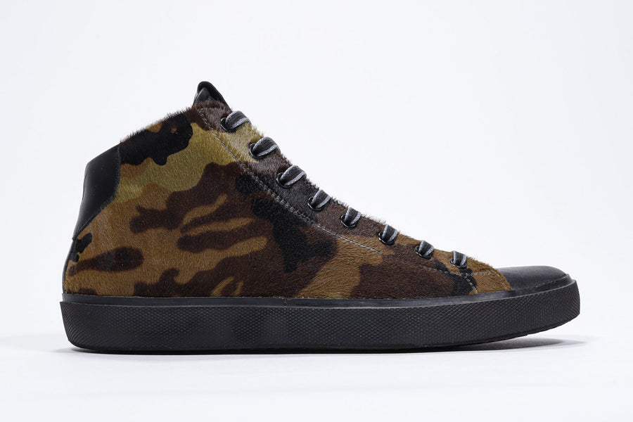 Side profile of mid top camouflage print sneaker with full hair calf leather upper, internal zip and black sole.