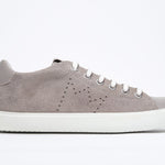 Side profile of low top beige sneaker with perforated crown logo on upper. Full suede upper and white rubber sole.
