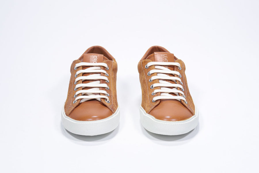 Front view of low top rust color sneaker with perforated crown logo on upper. Full suede upper and white rubber sole.