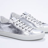 Tre quarti di BASSE argento sneaker con logo della corona traforato sulla tomaia. Tomaia in pelle metallizzata e suola in gomma bianca.