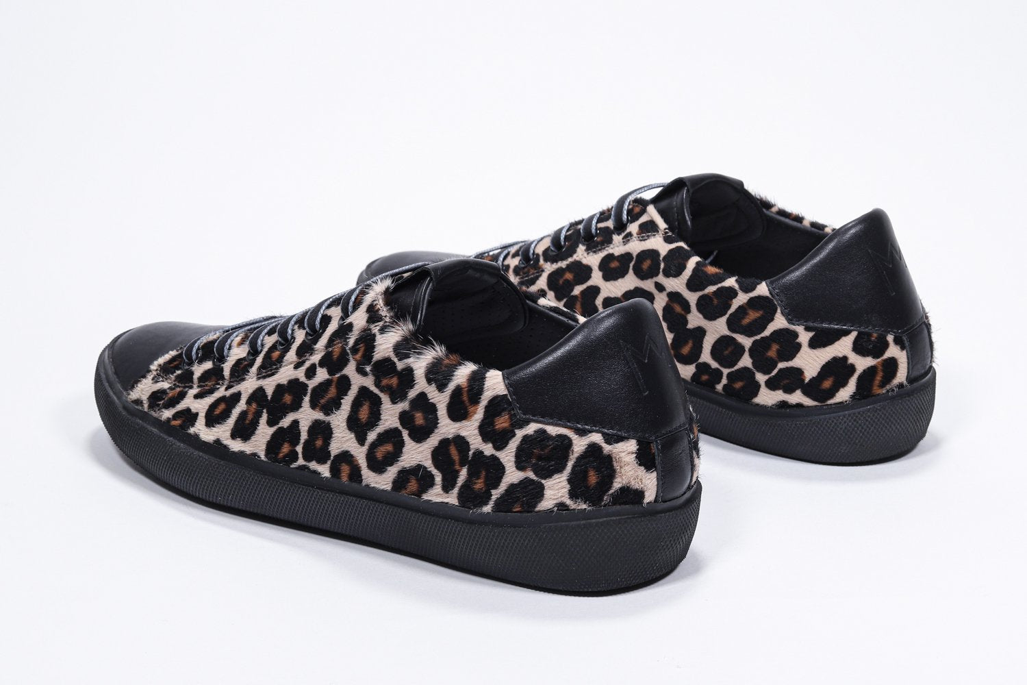 Vue de trois quarts arrière d'un modèle bas à imprimé léopard sneaker. Tige en cuir pleine fleur et semelle en caoutchouc noir.