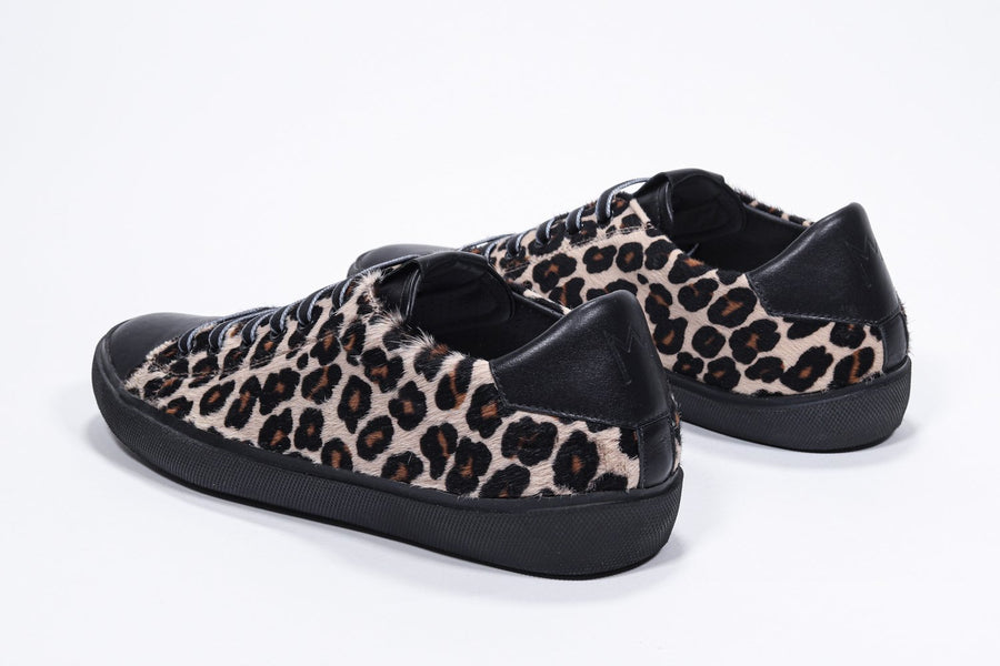 Three quarter back view of low top leopard print sneaker. Full haircalf leather upper and black rubber sole.