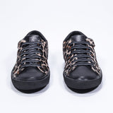 Vue de face de la chaussure à imprimé léopard sneaker. Tige en cuir pleine fleur et semelle en caoutchouc noir.