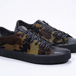 Dreiviertelansicht der Vorderseite von Low-Top-Camouflage-Druck sneaker. Obermaterial aus Haarkalbsleder und schwarze Gummisohle.