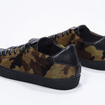 Vue de trois quarts arrière d'un modèle bas à imprimé camouflage sneaker. Tige en cuir pleine fleur et semelle en caoutchouc noir.