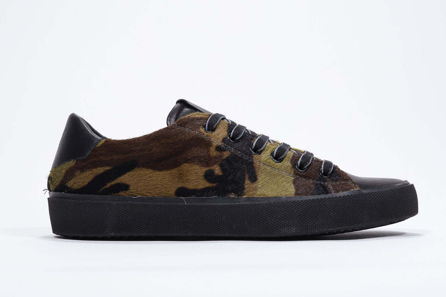 Side profile of low top camouflage print sneaker. Full haircalf leather upper and black rubber sole.