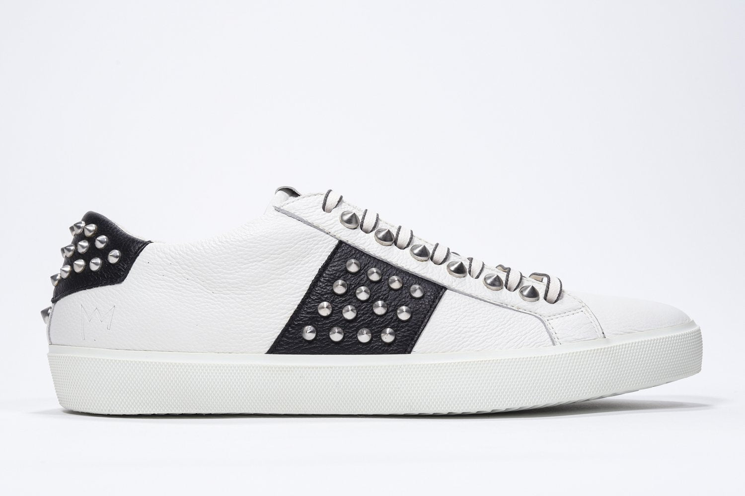 Profilo laterale di BASSE bianco e nero sneaker. Tomaia in pelle con borchie e suola in gomma bianca.