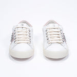 Front view of low top white and pale pink sneaker. Full leather upper with studs and vintage rubber sole.
