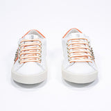 Vista frontale di BASSE bianco e arancione sneaker. Tomaia in pelle con borchie e suola in gomma vintage.