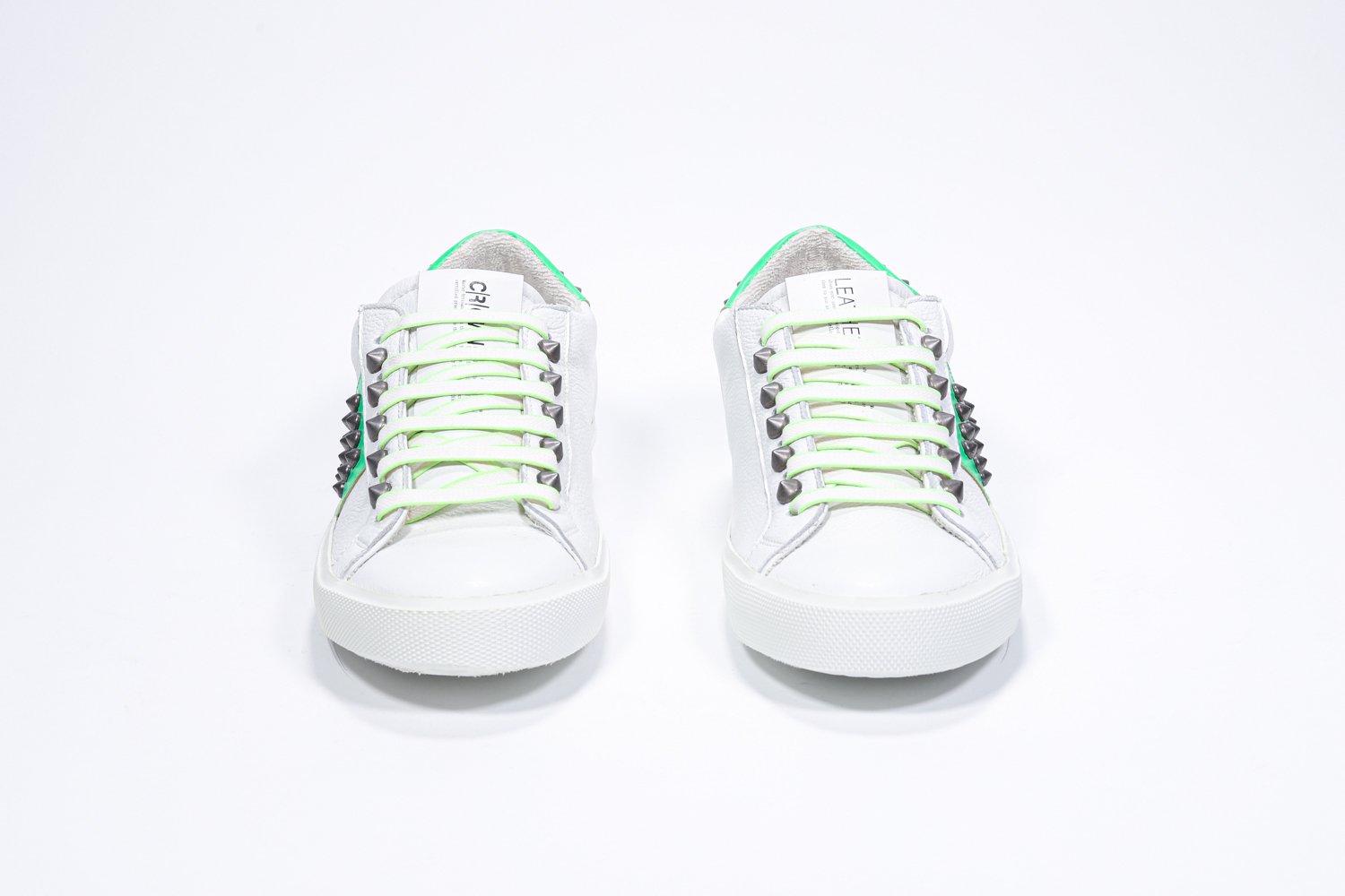 Vorderansicht des weißen und neongrünen Low Top sneaker. Obermaterial aus Vollleder mit Nieten und weißer Gummisohle.