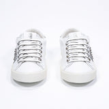 Vorderansicht von Low Top weiß und metallic silber sneaker. Obermaterial aus Vollleder mit Nieten und Vintage-Gummisohle.