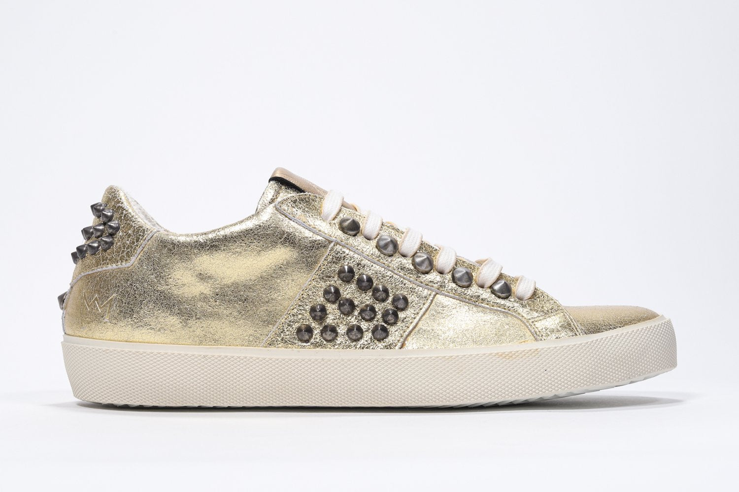 Profilo laterale di BASSE oro metallizzato sneaker. Tomaia in pelle con borchie e suola in gomma vintage.
