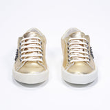Front view of low top metallic silver sneaker. Full leather upper with studs and vintage rubber sole.