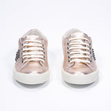 Front view of low top metallic rose sneaker. Full leather upper with studs and vintage rubber sole.
