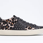 Profil latéral de la chaussure à imprimé léopard sneaker. Tige en cuir et en veau avec clous et semelle en caoutchouc vintage.