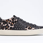 Side profile of low top leopard print sneaker. Full haircalf and leather upper with studs and vintage rubber sole.