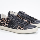 Three quarter front view of low top leopard print sneaker. Full haircalf and leather upper with studs and vintage rubber sole.