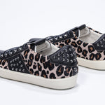 Three quarter back view of low top leopard print sneaker. Full haircalf and leather upper with studs and vintage rubber sole.