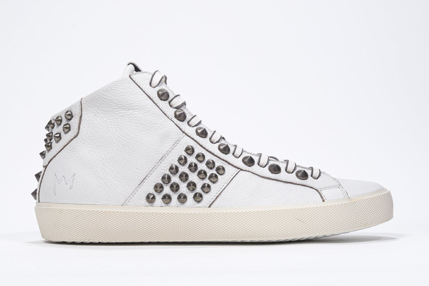 Side profile of mid top white sneaker. Full leather upper with studs, an internal zip and vintage rubber sole.