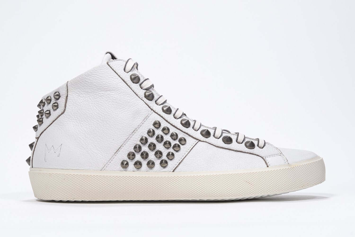 Side profile of mid top white sneaker. Full leather upper with studs, an internal zip and vintage rubber sole.