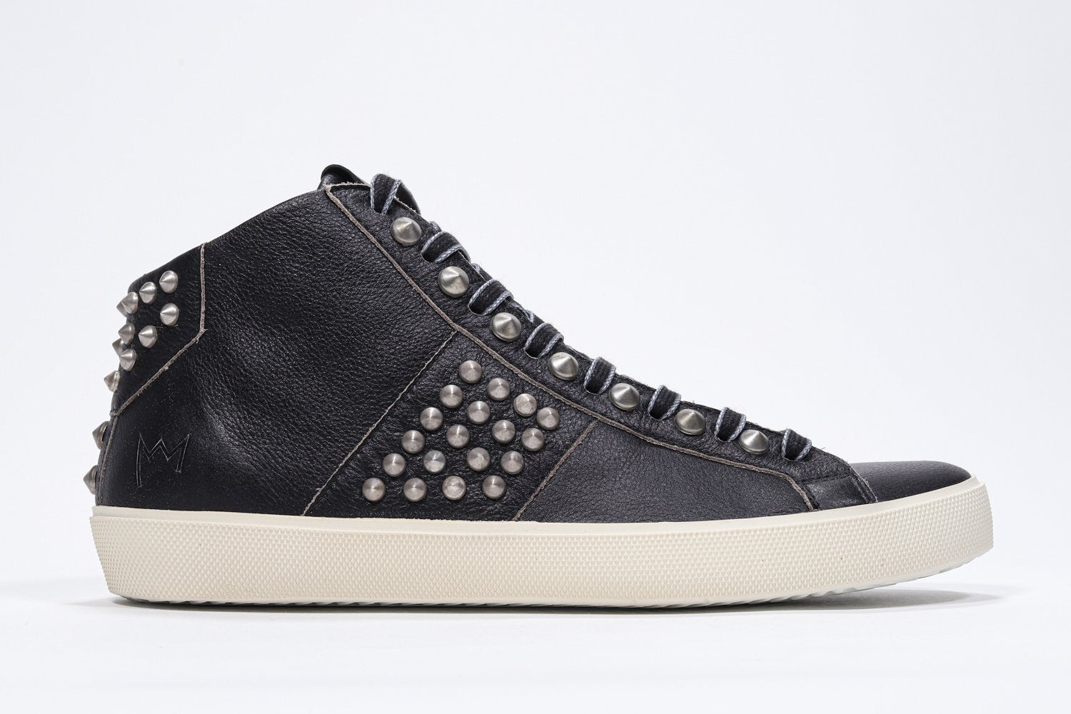 Profilo laterale di mid top nero sneaker. Tomaia in pelle con borchie, zip interna e suola in gomma vintage.