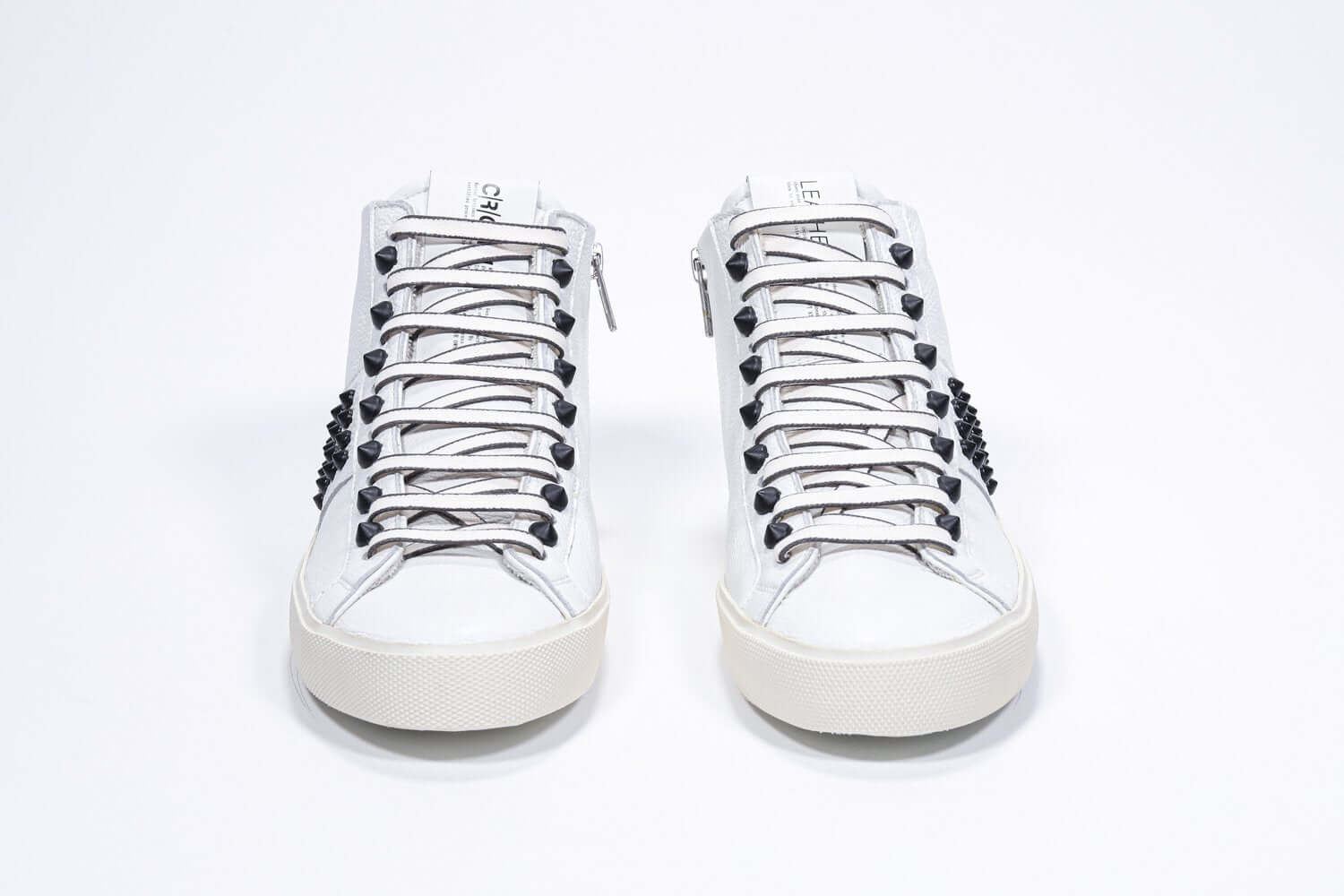 Vorderansicht des weißen Mid Top sneaker. Obermaterial aus Vollleder mit Nieten, einem internen Reißverschluss und einer Vintage-Gummisohle.
