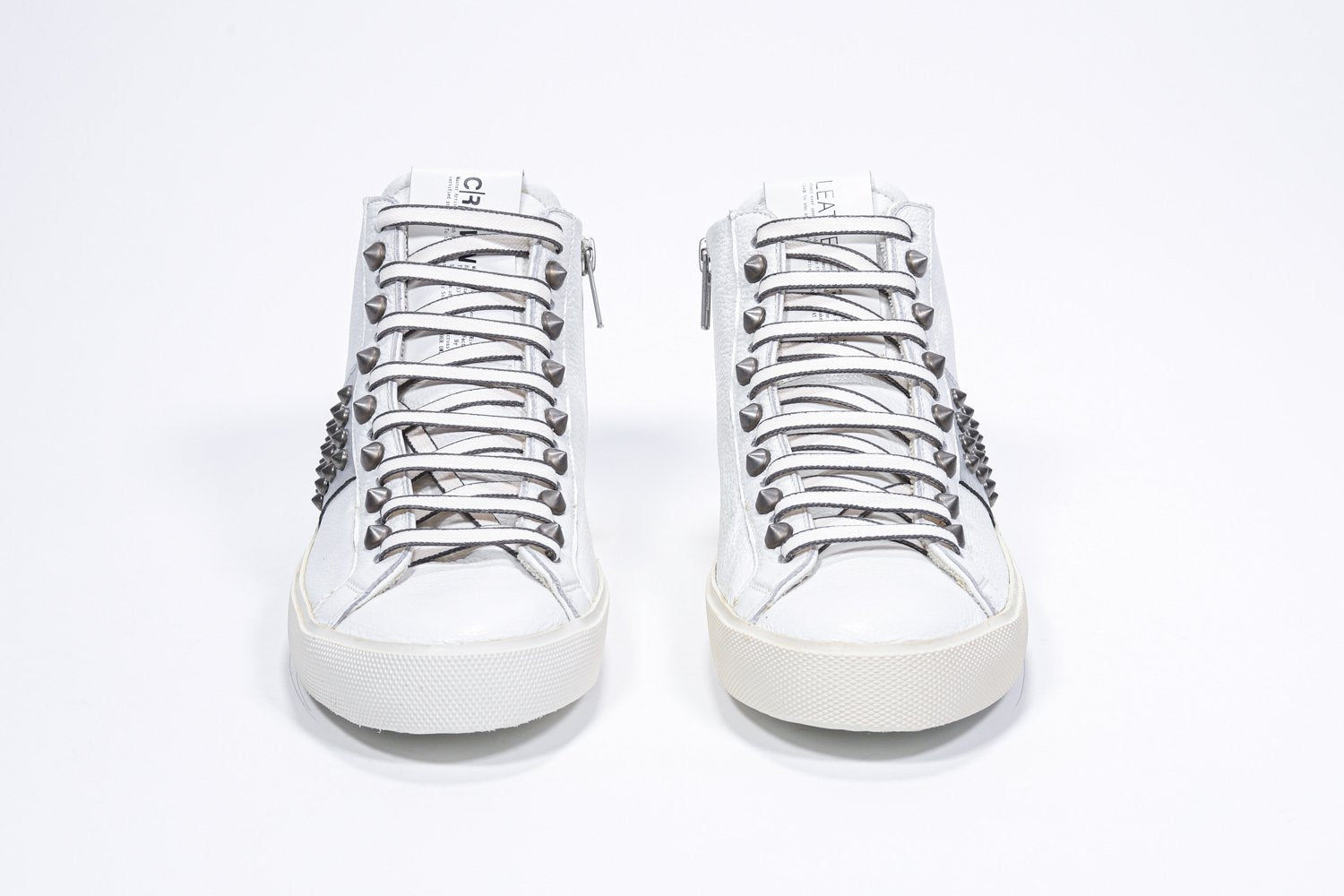 Vista frontale della mid top bianca e argento metallizzato sneaker. Tomaia in pelle con borchie, zip interna e suola in gomma vintage.