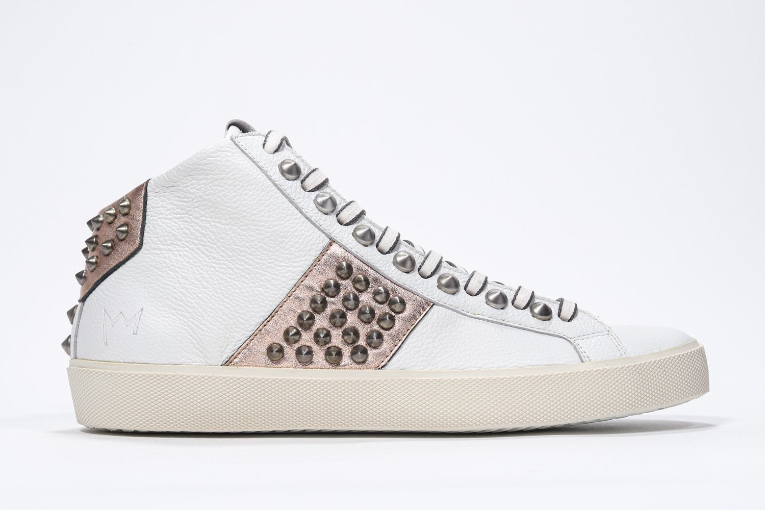 Side profile of mid top white and metallic rose sneaker. Full leather upper with studs, an internal zip and vintage rubber sole.