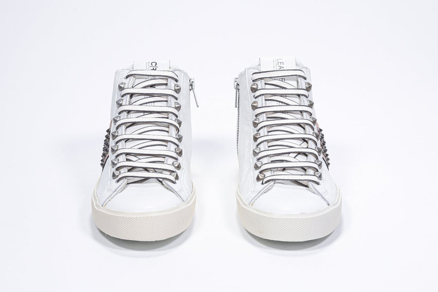 Front view of mid top white and metallic rose sneaker. Full leather upper with studs, an internal zip and vintage rubber sole.