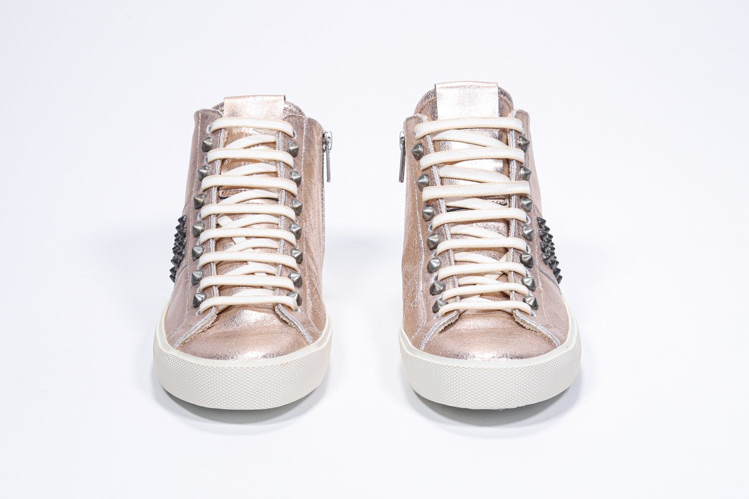 Vista frontale del mid top rosa metallizzato sneaker. Tomaia in pelle con borchie, zip interna e suola in gomma vintage.