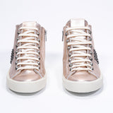 Vista frontale del mid top rosa metallizzato sneaker. Tomaia in pelle con borchie, zip interna e suola in gomma vintage.