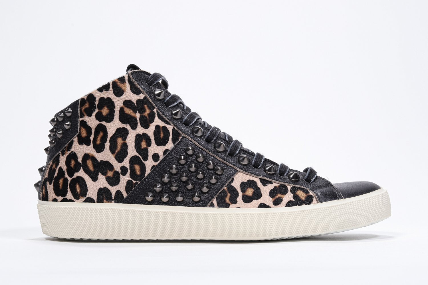 Profil latéral d'un modèle intermédiaire à imprimé léopard sneaker. Tige en cuir et poils avec clous, fermeture éclair intérieure et semelle en caoutchouc vintage.