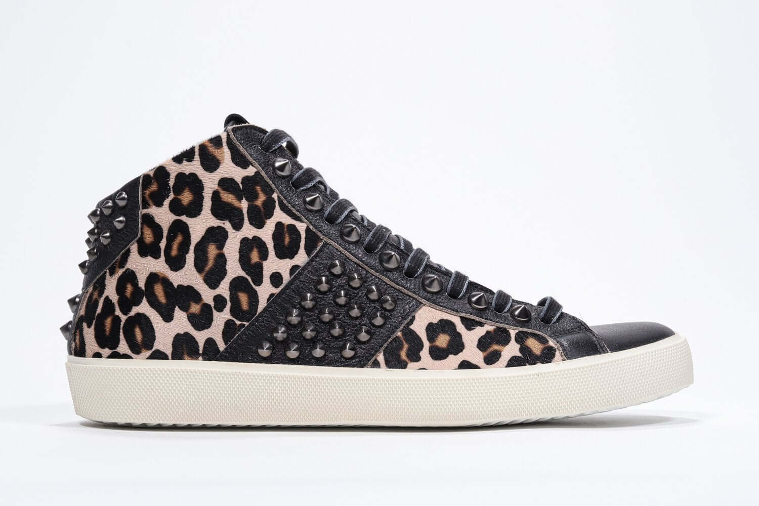 Side profile of mid top leopard print sneaker. Haircalf and leather upper with studs, an internal zip and vintage rubber sole.