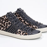 Three quarter front view of mid top leopard print sneaker. Haircalf and leather upper with studs, an internal zip and vintage rubber sole.