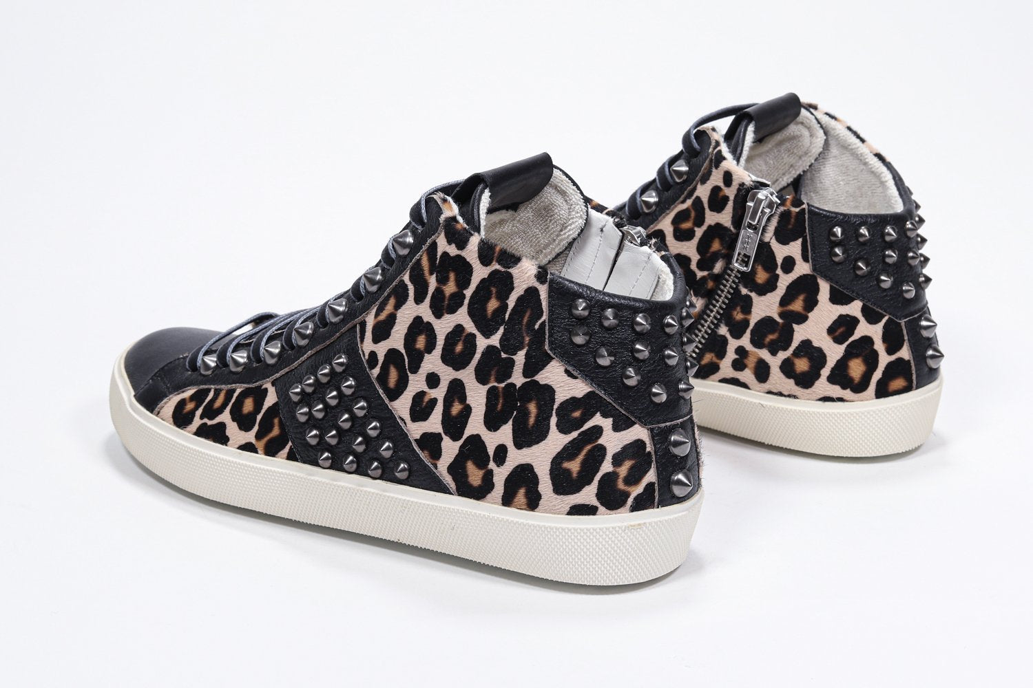 Three quarter back view of mid top leopard print sneaker. Haircalf and leather upper with studs, an internal zip and vintage rubber sole.