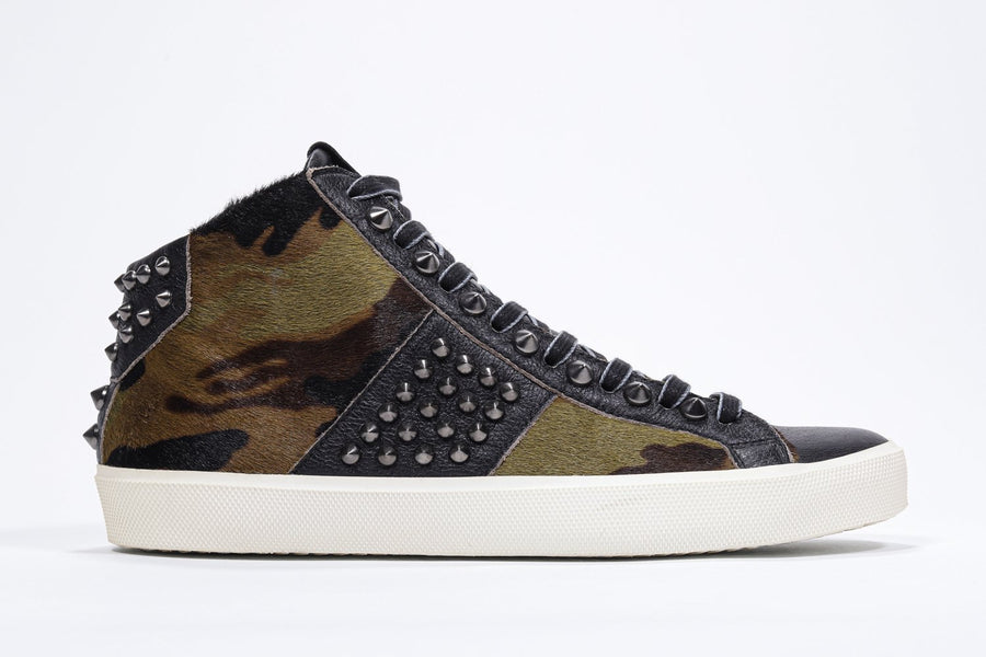 Side profile of mid top camouflage print sneaker. Haircalf and leather upper with studs, an internal zip and vintage rubber sole.