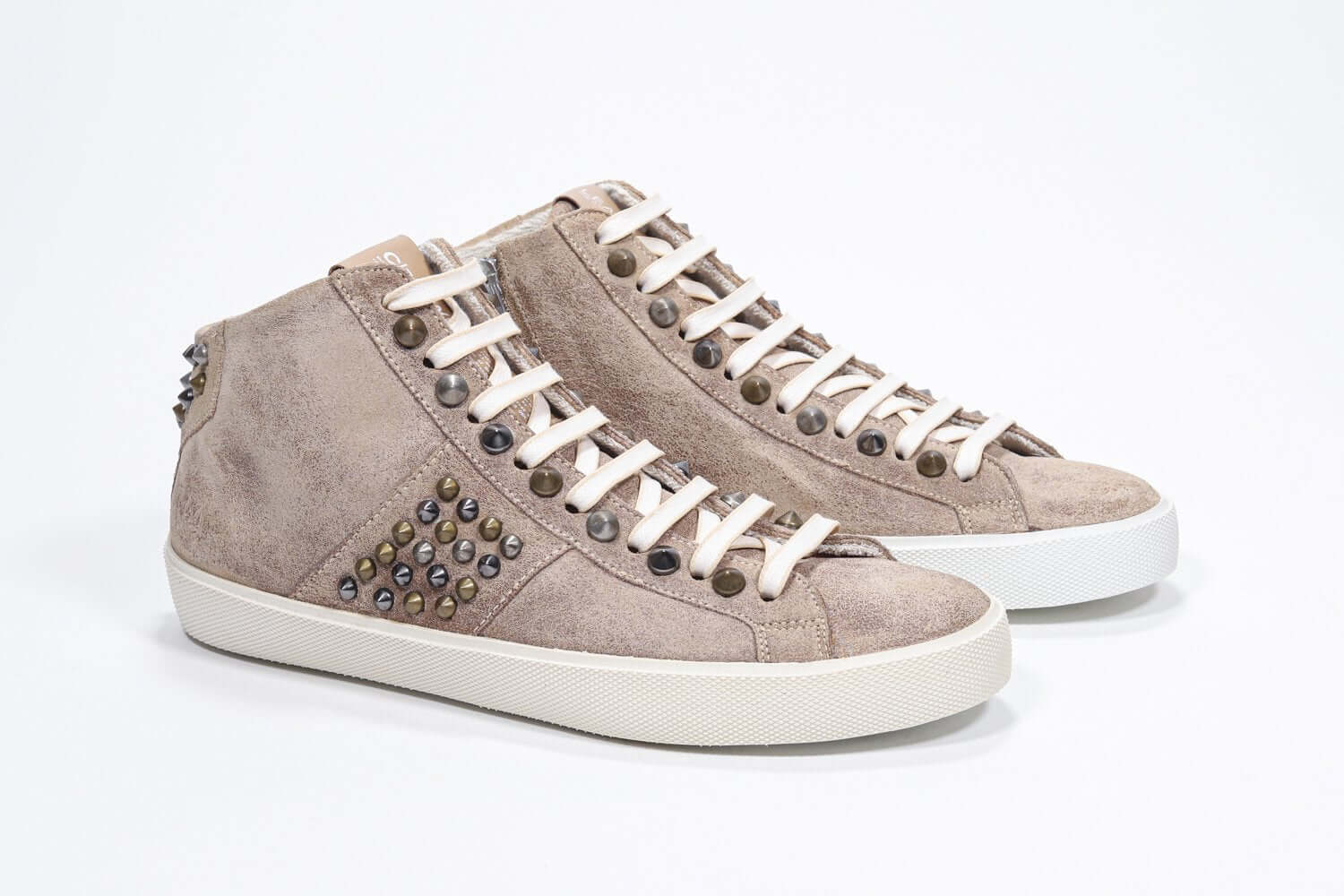 Three quarter front view of mid top cuoio color sneaker. Full suede upper with studs, an internal zip and vintage rubber sole.