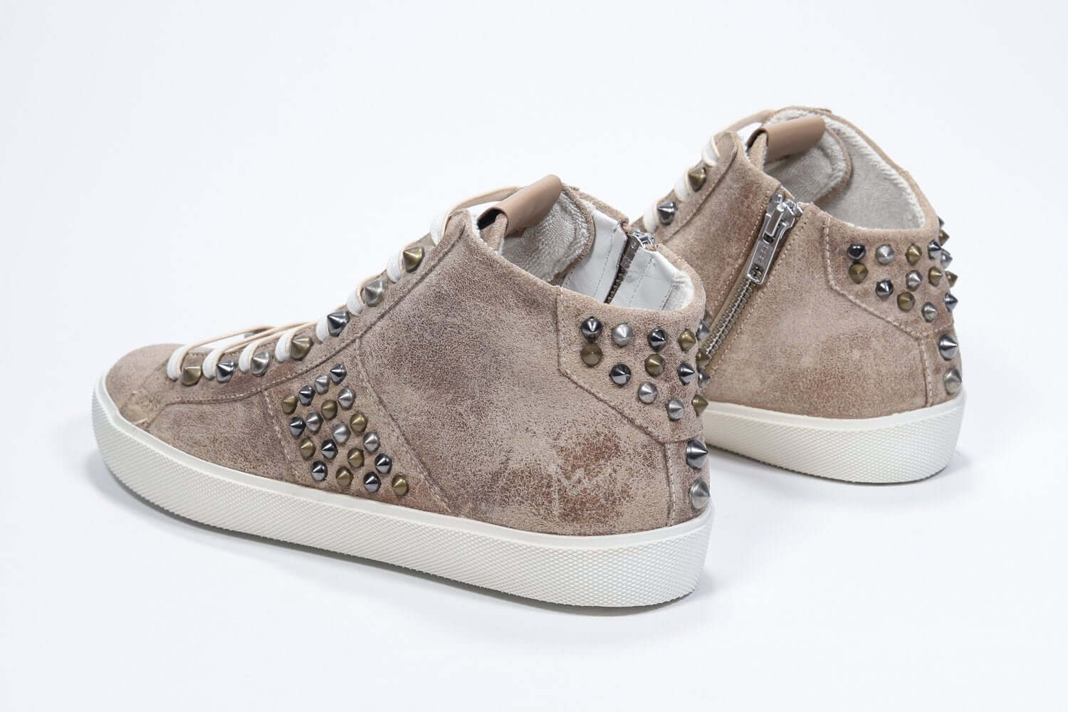 Three quarter back view of mid top cuoio color sneaker. Full suede upper with studs, an internal zip and vintage rubber sole.