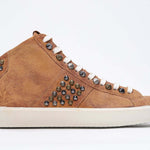 Side profile of mid top rust color sneaker. Full suede upper with studs, an internal zip and vintage rubber sole.