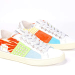 Three quarter front view of low top sneaker. Patchwork upper of mixed materials and silver studs.