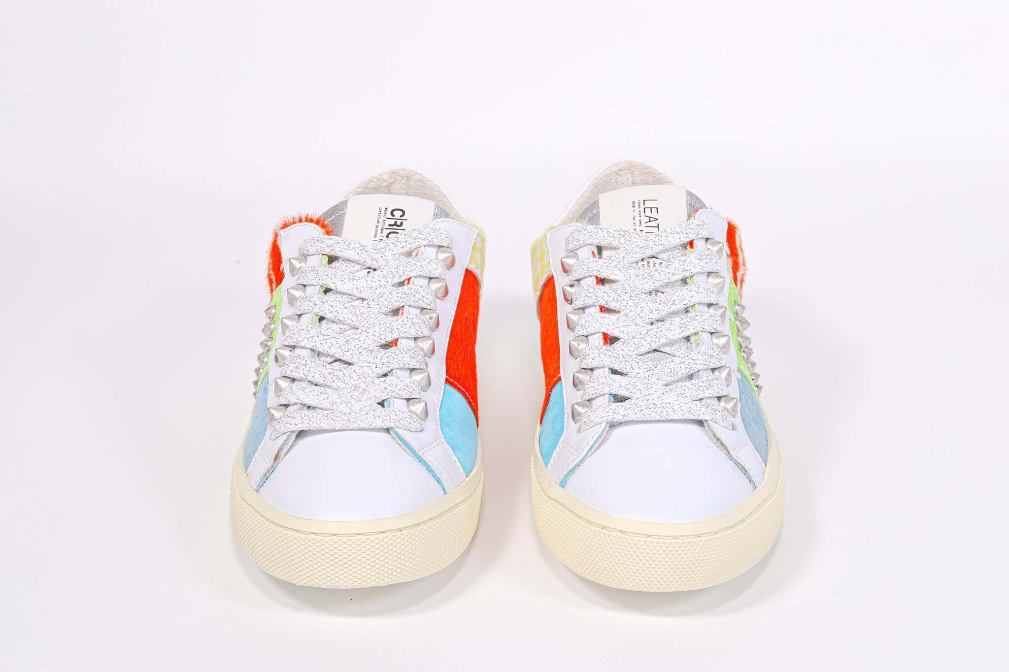 Vista frontale di BASSE sneaker . Tomaia patchwork di materiali misti e borchie d'argento.