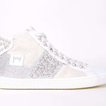 Side profile of mid top sneaker. Patchwork upper of mixed materials and silver studs.
