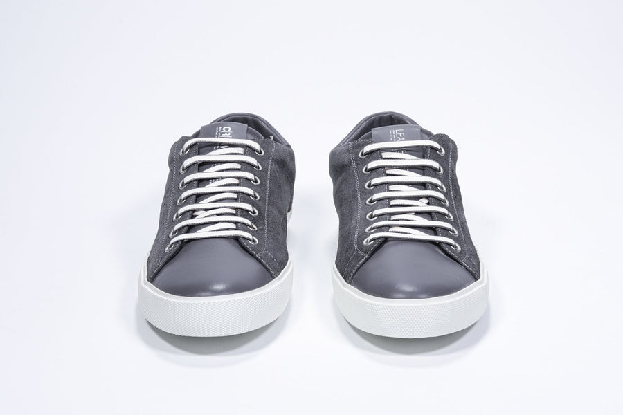 Vorderansicht des dunkelgrauen Low-Top-Sneakers mit perforiertem Kronenlogo auf dem Obermaterial. Obermaterial aus Vollwildleder und weiße Gummisohle.