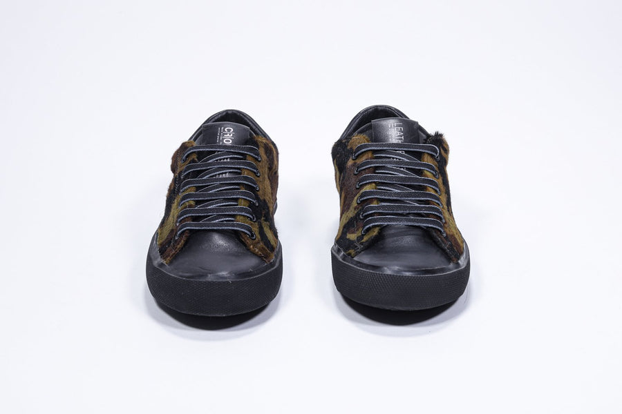 Vorderansicht des Low-Top-Sneakers mit Camouflage-Print. Obermaterial aus Haarkalbsleder und schwarze Gummisohle.