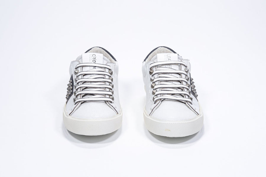 Vorderansicht von Low-Top-Sneaker in Weiß und Schwarz. Obermaterial aus Vollleder mit Nieten und Vintage-Gummisohle.