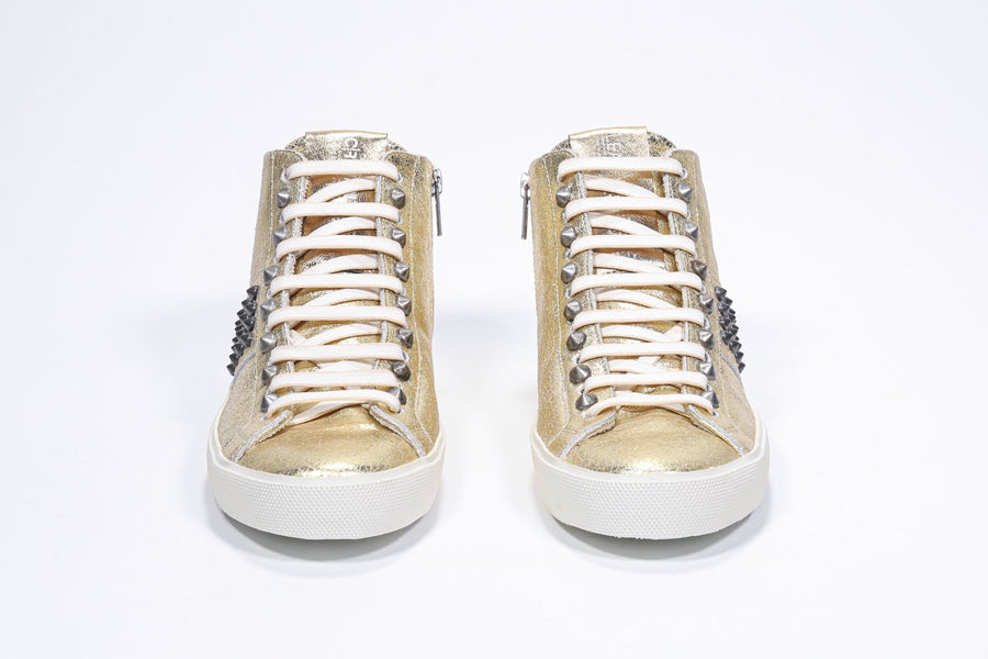 Vorderansicht des Mid-Top-Sneakers in Metallic-Gold. Obermaterial aus Vollleder mit Nieten, einem internen Reißverschluss und einer Vintage-Gummisohle.